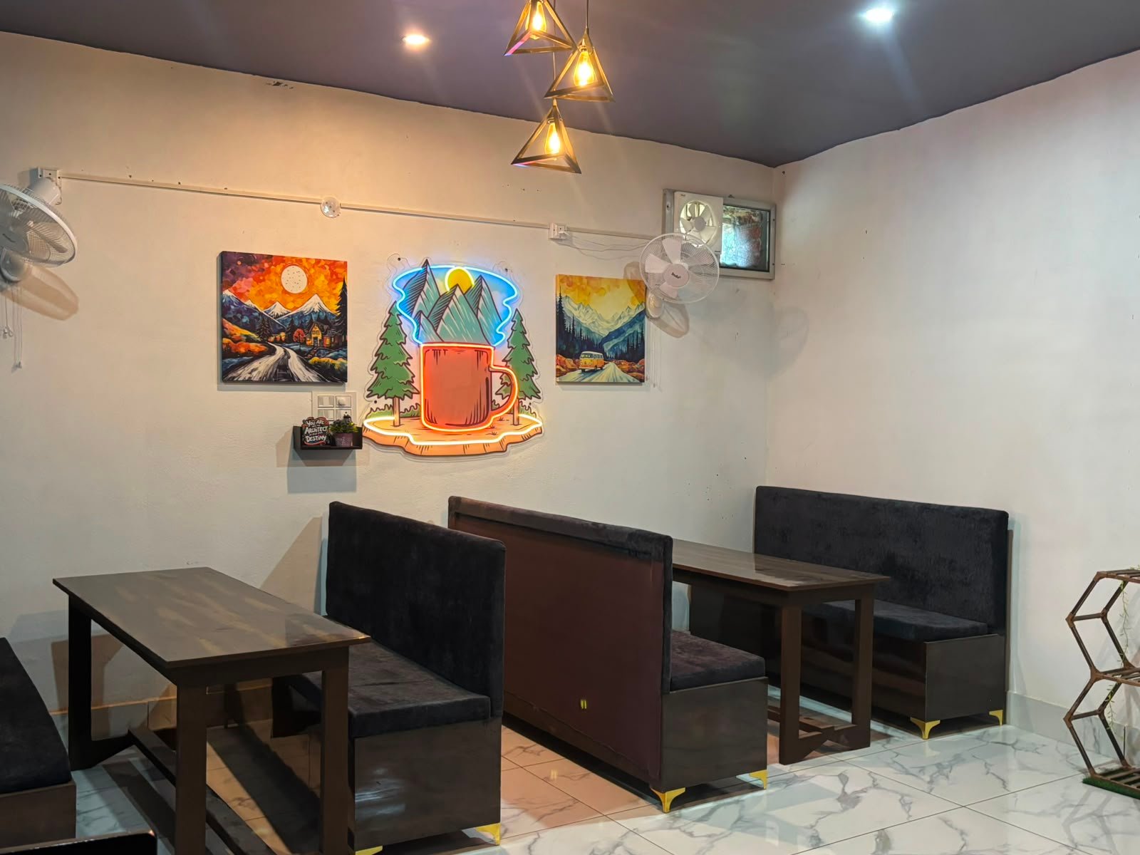 Bite & Byte café booth seating with neon mountain sign